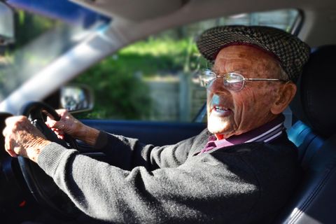 Älterer Herr fährt Auto und hat die Hände am Lenkrad