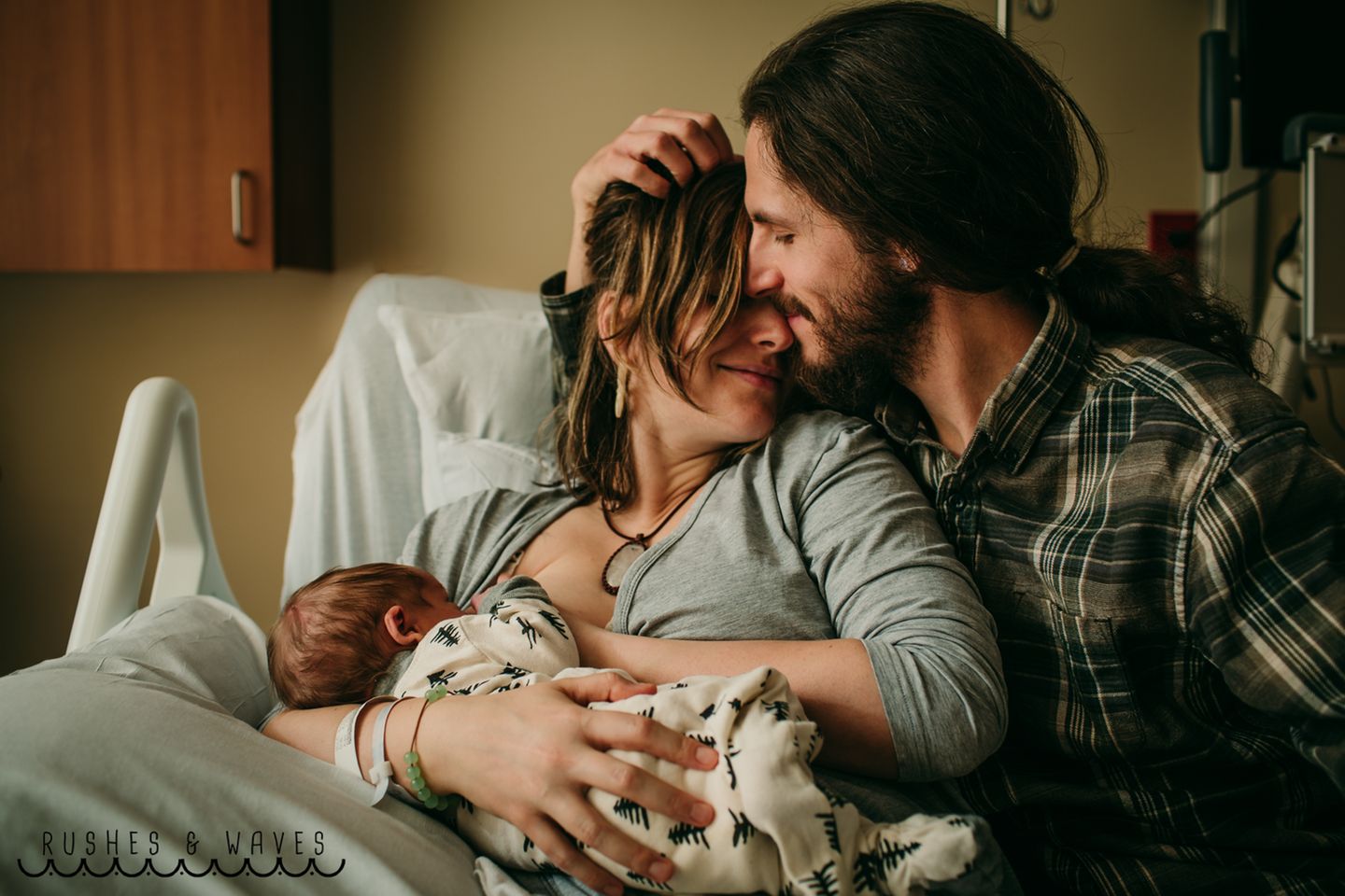 Eine Mutter stillt ihr Baby, der Vater schmust mit ihr