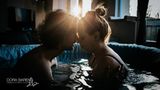 Bei einer Wassergeburt sitzen Vater und Mutter Stirn an Stirn in der Wanne