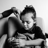 Ein kleines Mädchen hält seinen Baby-Bruder in Arm und muss weinen