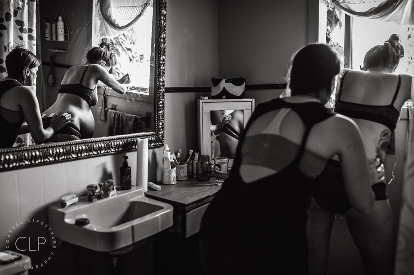 Eine Frau massiert den Rücken einer werdenden Mutter in den Wehen