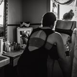 Eine Frau massiert den Rücken einer werdenden Mutter in den Wehen