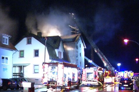 Feuerwehrleute löschen den Brand in einem Mehrfamilienhaus in Lambrecht in Rheinland-Pfalz