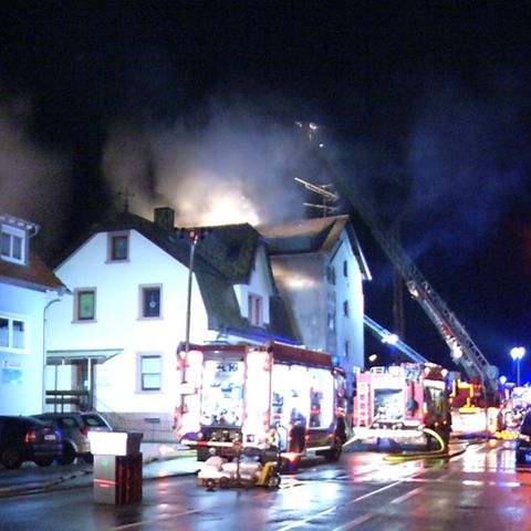 Feuerwehrleute löschen den Brand in einem Mehrfamilienhaus in Lambrecht in Rheinland-Pfalz
