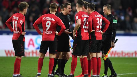 Schiedsrichter Felix Brych diskutiert mit Freiburger Spielern