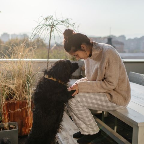 Frau mit Hund auf Balkon