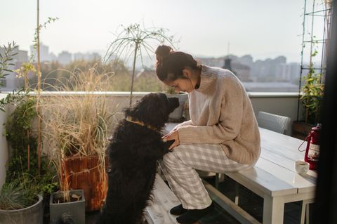 Frau mit Hund auf Balkon
