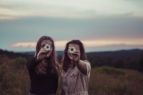 Zwei Freundinnen mit Blumen in der Hand