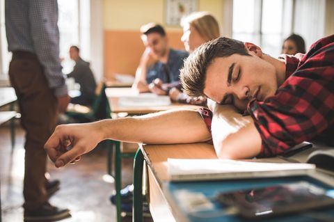 Ein Schüler schläft im Unterricht ein