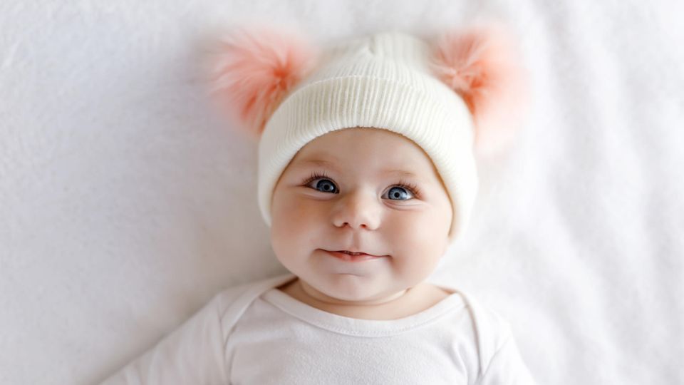 Ein Baby strahlt mit großen Augen in die Kamera