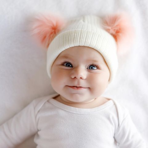 Ein Baby strahlt mit großen Augen in die Kamera