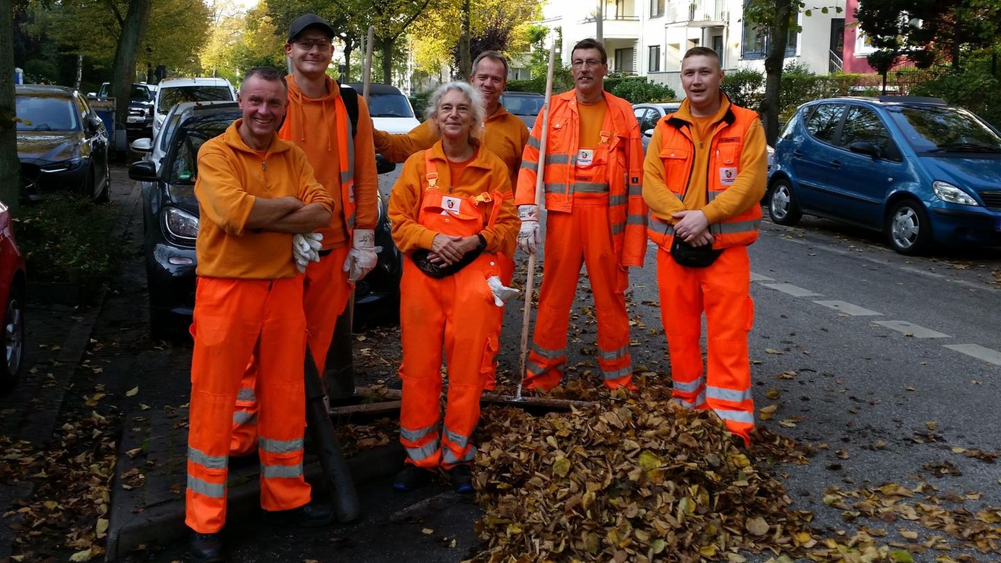 Vier Straßenreiniger stehen um die Autorin, alle in organgener Leucht-Ausrüstung