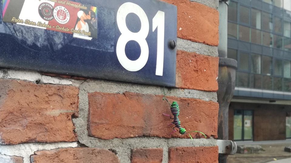 Eine Ameise aus Draht sitzt an einer Hauswand