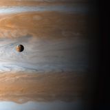 Aufgenommen von der Raumsonde Cassini: Der Jupitermond Io wird von dem Planeten, den er umkreist, in den Schatten gestellt.