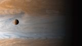 Aufgenommen von der Raumsonde Cassini: Der Jupitermond Io wird von dem Planeten, den er umkreist, in den Schatten gestellt.