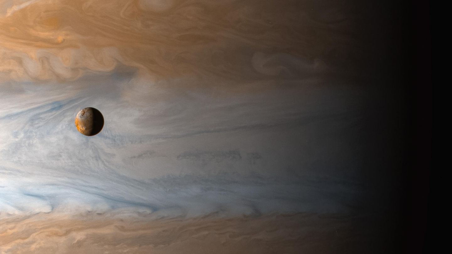 Aufgenommen von der Raumsonde Cassini: Der Jupitermond Io wird von dem Planeten, den er umkreist, in den Schatten gestellt.