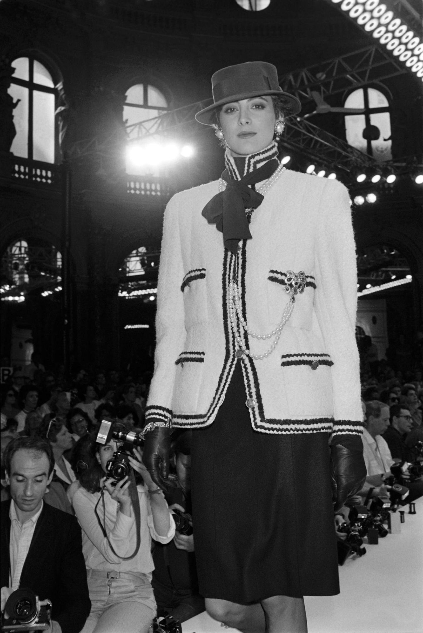 Karl Lagerfeld für Chanel Auch in den Folgejahren zeigt sich Model und Lagerfeld-Muse Ines de la Fressange in den Kreationen des Designers auf dem Laufsteg. Hier in dem wohl größten Klassiker des Modezars: einem Tweedanzug. Die Perlen-Accessoires und Handschuhe runden diesen und viele weitere Chanel-Looks von Lagerfeld ab. Das Outfit stammt aus der Herbst/Winter-Kollektion von 1985.