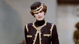Karl Lagerfeld machte die Uniform auf der Straße tragbar. Viele Chanel-Looks waren an sie angelehnt. Hier mit goldenen Verzierungen, dem typischen Gürtel und Perlen-Details. Dieser Look stammt aus der Herbst/Winter-Kollektion von 1989/1990.