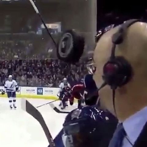 Ein Eishockey-Puck fliegt nur Zentimeter an der Stirn eines TV-Kommentators vorbei