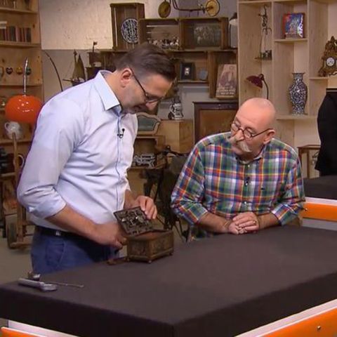 Verkäufer Markus Andree und Horst Lichter sehen sich Schatztruhe an