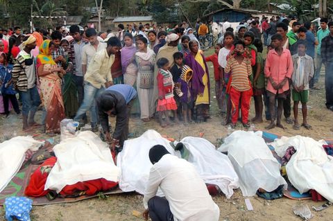 Indien, Golaghat: Menschen stehen vor den Leichen von Opfern, die an giftigem Alkohol gestorben waren