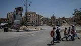 Kinder überqueren den Al-Raschidin-Platz, Assad grüßt von der Plakatwand