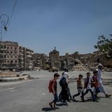 Kinder überqueren den Al-Raschidin-Platz, Assad grüßt von der Plakatwand