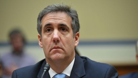 Michael Cohen sitzt in Anzug und Krawatte vor einem Mikrofon und scheint gerade einer Frage zu lauschen