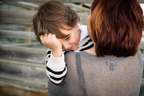 Eine Mutter trägt ihren Sohn auf dem Arm