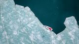 Vor Anker im Gletschereis am Billefjord, Spitzbergen. Das Boot wird mit Haken im Eis vertäut, dann können die Besucher an Land gehen.