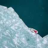 Vor Anker im Gletschereis am Billefjord, Spitzbergen. Das Boot wird mit Haken im Eis vertäut, dann können die Besucher an Land gehen.