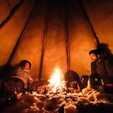 Espen Prestbakmo (l.) und ein Freund beim Plausch am Feuer. Die Zelte der Sami werden auch Tipi des Nordens genannt.
