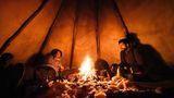 Espen Prestbakmo (l.) und ein Freund beim Plausch am Feuer. Die Zelte der Sami werden auch Tipi des Nordens genannt.
