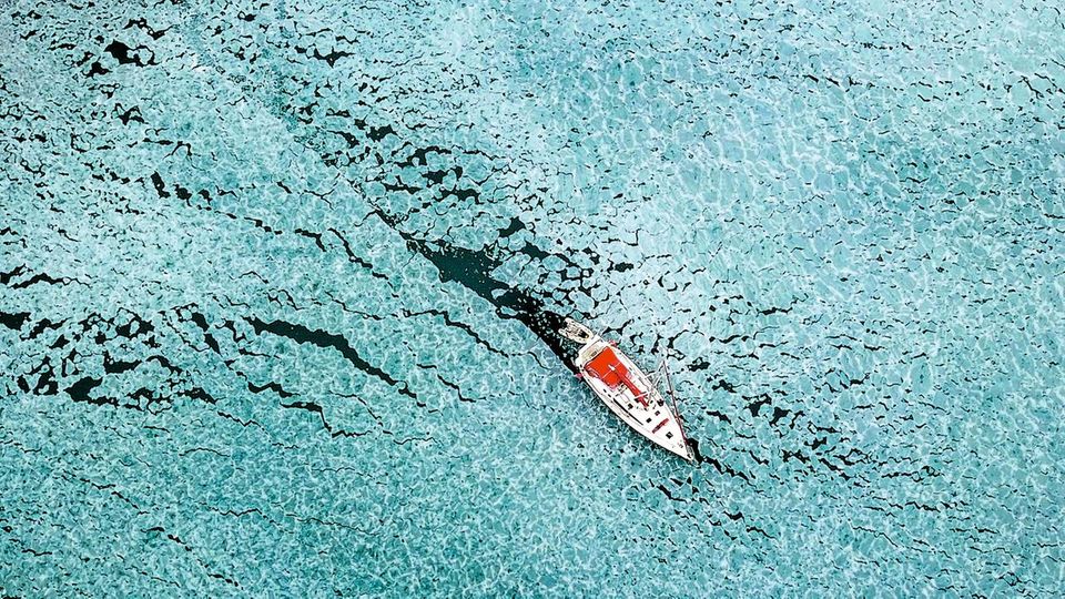 Reisefotografie: Wie ein Pfeil bahnt sich Delphines Boot einen Weg durch die Bucht von Trygghamna. Sie muss dabei Schollen von massivem Eis unterscheiden – sonst steckt das Boot fest. Wie ein Pfeil bahnt sich Delphines Boot einen Weg durch die Bucht von Trygghamna. Sie muss dabei Schollen von massivem Eis unterscheiden – sonst steckt das Boot fest.