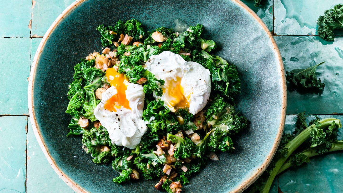 Rührgebratener Grünkohl mit Vinaigrette, Haselnüssen, Schinken und pochiertem Ei