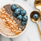 ... in dieser Smoothie-Bowl stecken Milch, Joghurt, eine gefrorene Banane und ein paar Eiswürfel. Alles zusammen in einem großen Mixer pürieren und mit Beeren und Nüssen garnieren. So entsteht ein fruchtig-kaltes Dessert mit wertvollen Vitaminen und Ballaststoffen, das ohne zugesetzten Zucker auskommt.