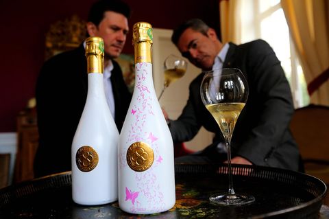 Zwei Flaschen Champagner – auf der Rechten ist ein pinkes Muster