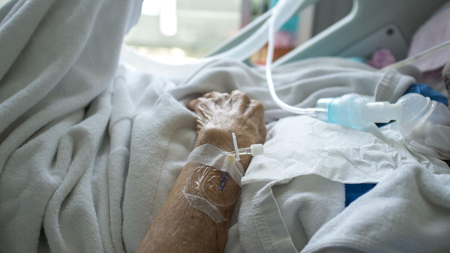 Ein Mann liegt in einem Krankenhausbett