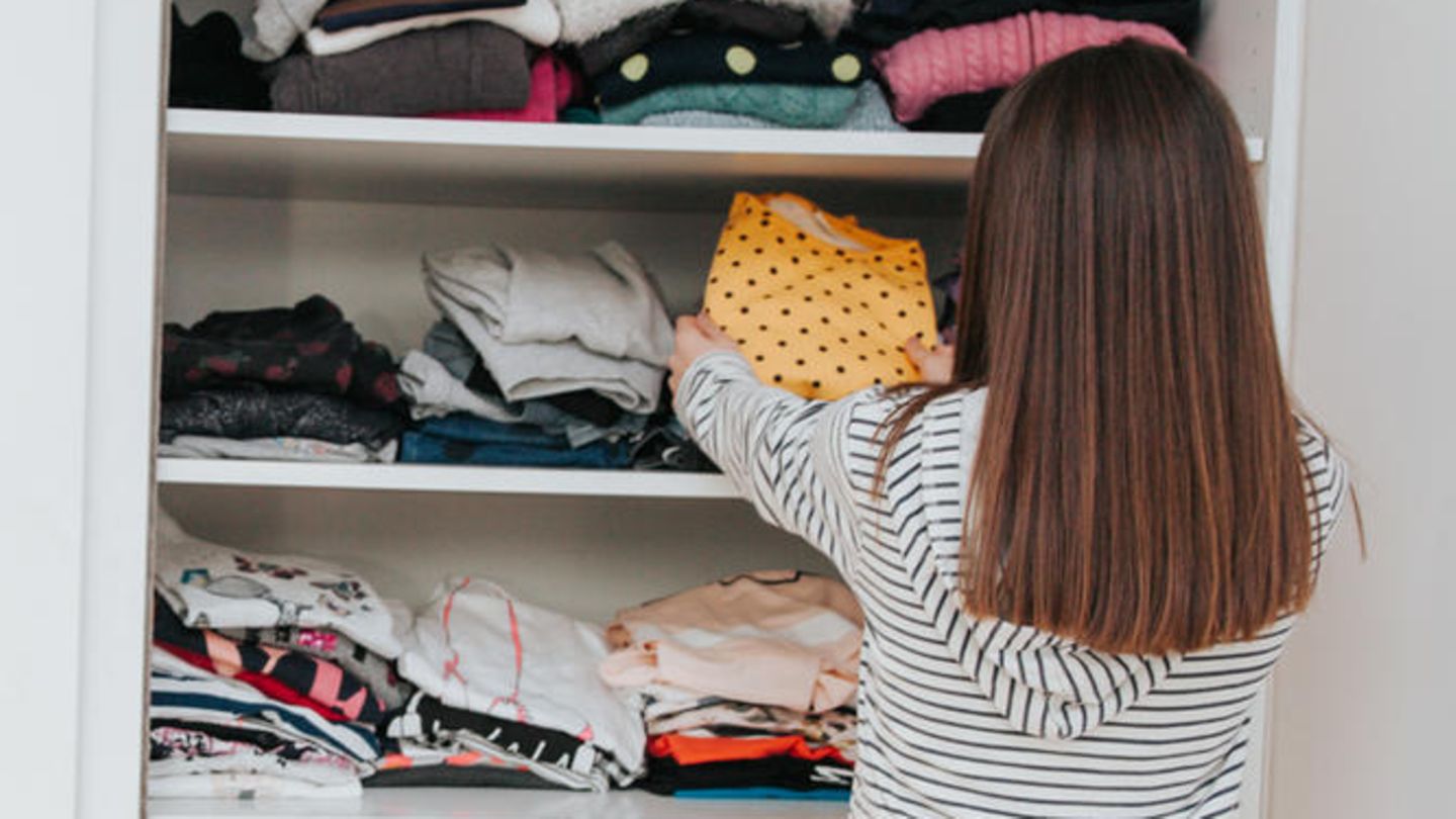 Mädchen sortiert seinen Kleiderschrank