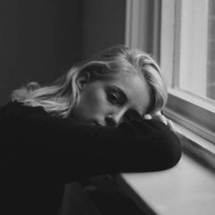 Traurige Frau an Fenster
