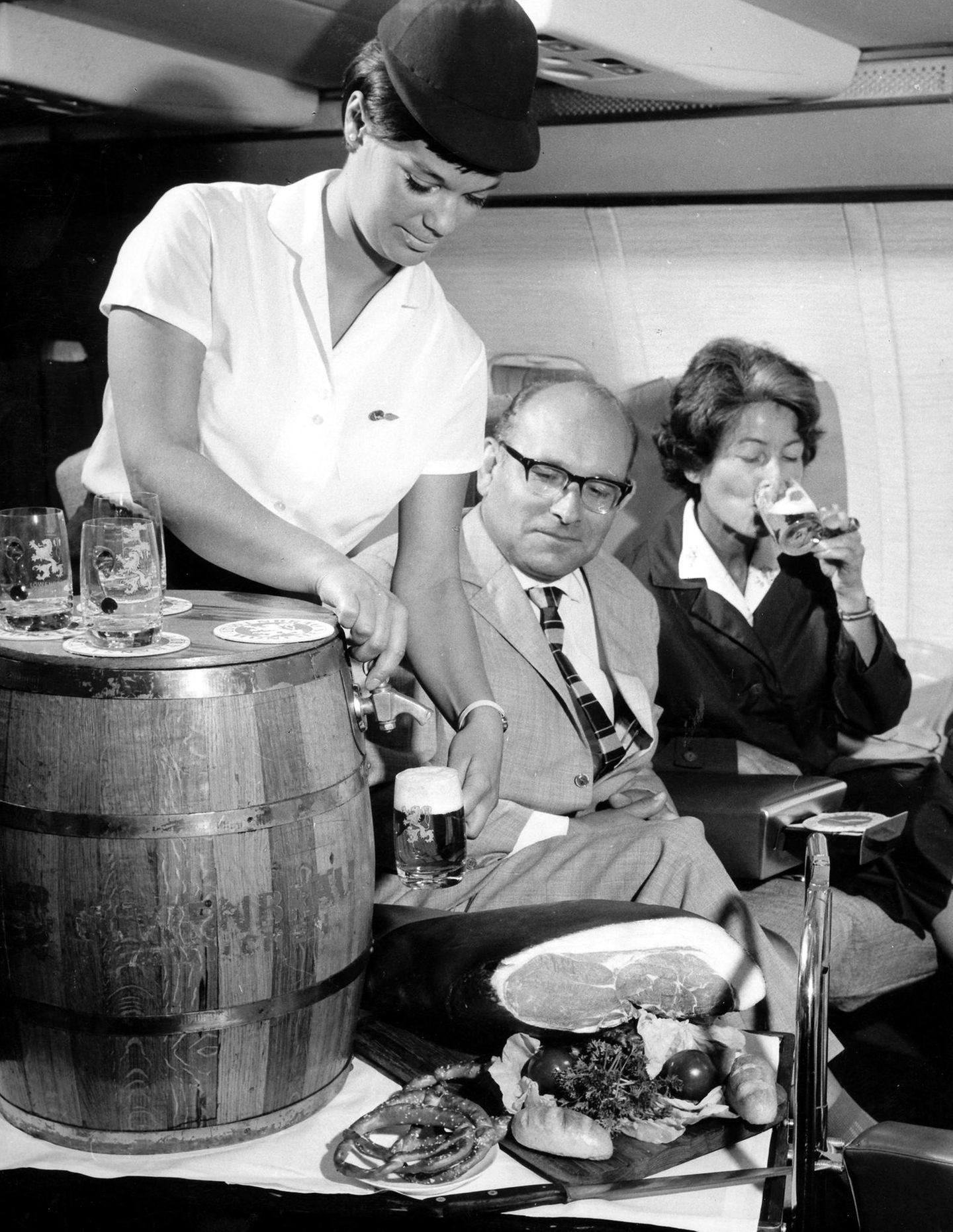 Senator Service in den späten 50er Jahren: Eine Stewardess der Lufthansa zapft in 10.000 Metern Höhe Bier vom Fass
