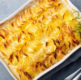 Kartoffelgratin nach Léa Linster  Für 4 Personen, Zubereitung: 20 Minuten Garzeit: 70 Minuten  Zutaten:  1 Knoblauchzehe, 1 kg vorwiegend festkochende Kartoffeln, 250 ml Milch, 250 g Sahne, frisch geriebene Muskatnuss, Salz, 40 g Butter + Butter für die Form  Zubereitung:  1. Den Backofen auf 170° vorheizen. Den Knoblauch schälen und halbieren. Eine flache ofenfeste Form zuerst mit der Knoblauchzehe einreiben, dann mit etwas Butter ausstreichen.  2. Die Kartoffeln schälen, waschen und in ca. 1 ½ mm dicke Scheiben hobeln oder schneiden. Die Kartoffelscheiben lagenweise in die Form schichten.  3. Die Milch mit der Sahne verquirlen, mit Muskatnuss und Salz kräftig würzen. Die Flüssigkeit über die Kartoffelscheiben gießen, sodass die Auflaufform ca. zu zwei Dritteln gefüllt ist. Dann die Butter in Flocken auf das Gratin setzen und im Ofen (Mitte) in 70 Min. weich garen.