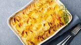 Kartoffelgratin nach Léa Linster  Für 4 Personen, Zubereitung: 20 Minuten Garzeit: 70 Minuten  Zutaten:  1 Knoblauchzehe, 1 kg vorwiegend festkochende Kartoffeln, 250 ml Milch, 250 g Sahne, frisch geriebene Muskatnuss, Salz, 40 g Butter + Butter für die Form  Zubereitung:  1. Den Backofen auf 170° vorheizen. Den Knoblauch schälen und halbieren. Eine flache ofenfeste Form zuerst mit der Knoblauchzehe einreiben, dann mit etwas Butter ausstreichen.  2. Die Kartoffeln schälen, waschen und in ca. 1 ½ mm dicke Scheiben hobeln oder schneiden. Die Kartoffelscheiben lagenweise in die Form schichten.  3. Die Milch mit der Sahne verquirlen, mit Muskatnuss und Salz kräftig würzen. Die Flüssigkeit über die Kartoffelscheiben gießen, sodass die Auflaufform ca. zu zwei Dritteln gefüllt ist. Dann die Butter in Flocken auf das Gratin setzen und im Ofen (Mitte) in 70 Min. weich garen.