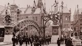 Eine Menschenansammlung an der Brooksbrücke im November 1888. Im Hintergrund die Lagerhäuser der Speicherstadt.