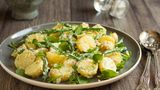 Kartoffelsalat mit Kürbiskernöl und Feldsalat      Zutaten für vier Portionen:      600 Gramm Kartoffeln (achten Sie darauf, dass die Kartoffeln mehlig oder festkochend sind)  200 Milliliter Gemüsebrühe  2 Zwiebeln  3 Esslöffel Senf  2 Esslöffel Zucker  5 Esslöffel Apfelessig  4 Esslöffel Öl  4 Esslöffel Kürbiskernöl  100 Gramm Feldsalat  80 Gramm Kürbiskerne  Pfeffer und Salz      Zubereitung:       Die Kartoffeln in einem Topf (ungepellt, bei geschlossenem Deckel) etwa 10 Minuten kochen lassen Die Kürbiskerne in einer flachen Pfanne anrösten (Achten Sie darauf, dass die Kerne nicht anbrennen und schütteln Sie die Pfannen hin und wieder) Die Kürbiskerne nun mit etwas Salz abschmecken und anschließend unter Zugabe von ein wenig Zucker karamellisieren Die Kürbiskerne beiseite Stellen (werden erst wieder zum Anrichten benötigt) Hacken sie zwei Zwiebeln klein, geben Sie diese in einen Topf/eine Pfanne und braten Sie die Zwiebel glasig an – zum Schluss mit der Gemüsebrühe ablöschen Pellen Sie jetzt die (möglichst noch heißen) Kartoffeln Schneiden Sie die Kartoffeln in 4 Millimeter breite Scheiben Geben Sie die noch warmen Kartoffeln in eine Schüssel zusammen mit der Brühe und übergießen Sie das Ganze mit den angebratenen Zwiebeln Geben Sie zu Kartoffeln, Zwiebeln und Brühe noch 3 Esslöffel Senf dazu Gut vermengen, solange die Mischung noch warm ist Noch Apfelessig, Salz, ein wenig Zucker und Pfeffer zu dem Salat geben, abschließend einen Schuss Kürbiskernöl dazugeben Den Kartoffelsalat für etwa 15 Minuten ziehen lassen, bis er abgekühlt ist Feldsalat unter den Kartoffelsalat heben Jetzt die vorbereiteten Kürbiskerne hinzugeben. Mit ein wenig Kürbiskernöl beträufeln.  pimpmyfastfood