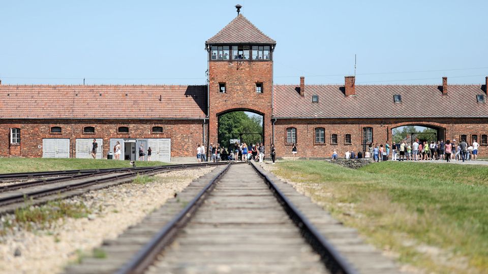 Auschwitz-Birkenau: Besucher gehen vor dem historischen Tor (Innenneite) durch das frühere Vernichtungsslager