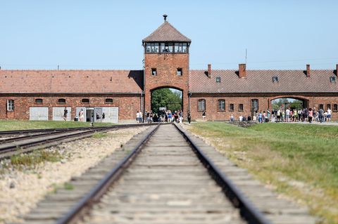 Auschwitz-Birkenau: Besucher gehen vor dem historischen Tor (Innenneite) durch das frühere Vernichtungsslager