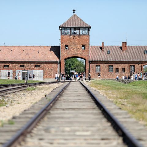 Auschwitz-Birkenau: Besucher gehen vor dem historischen Tor (Innenneite) durch das frühere Vernichtungsslager