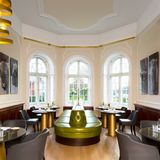 Kategorie Restaurant  Erster Preis: Blüchers - Göhren Lebbin  Innenarchitekt Olaf Kitzig über das Zusammenspiel von historisch und modern: "In den Räumen von 1842 fanden wir Stuck sowie eine authentische Feuerstelle vor. Sie konnten wie die Decke aus Tiffanyglas erhalten bleiben. So entsteht Spannung zwischen dem Baudenkmal und dem neuen Interior."