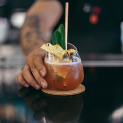 Mann stellt Cocktail auf Tresen